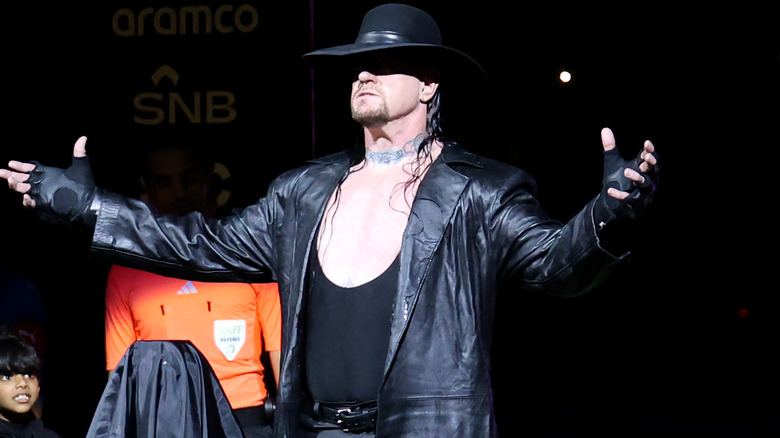 The Undertaker with his hat over his eyes