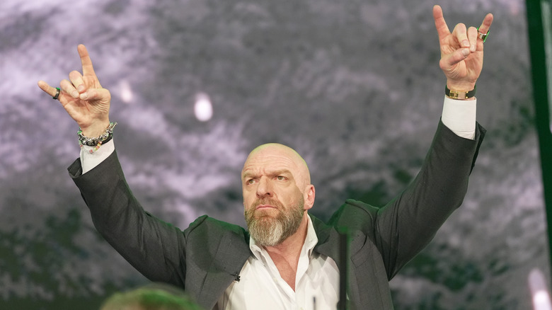 Triple H gives the rock and roll gesture (also known as the sign of the horns) to fans during a conference event at WrestleMania 41