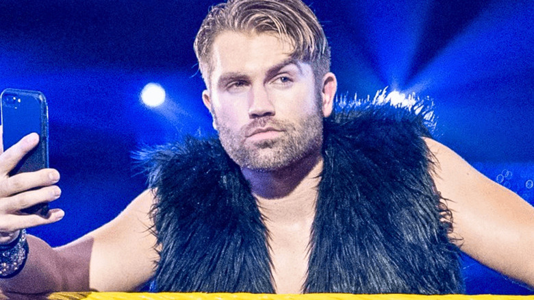 Tyler Breeze wearing a navy-blue fur vest