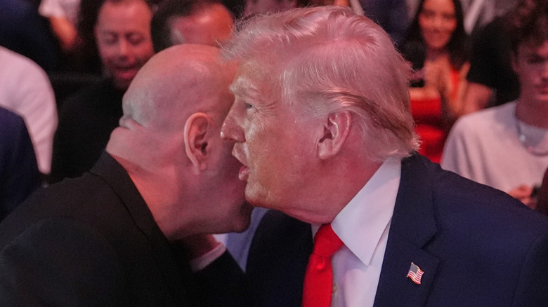 President Donald Trump talks in the ear of Dana White at UFC 327