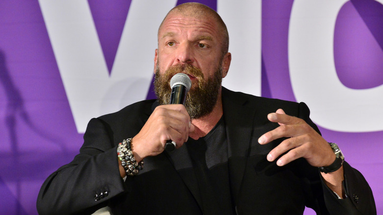 Triple H responds to a question from a press member during a media scrum