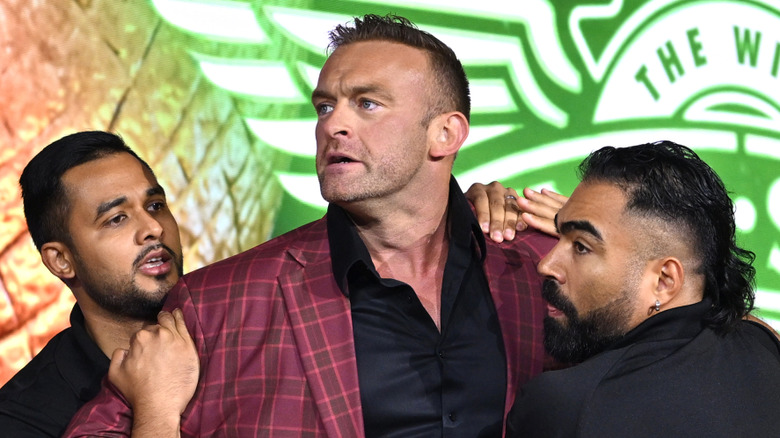 Nick Aldis standing in front of a Wingstop logo