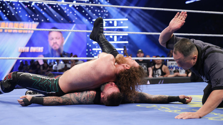 WWE referee counts as Sami Zayn pins Kevin Owens in the ring