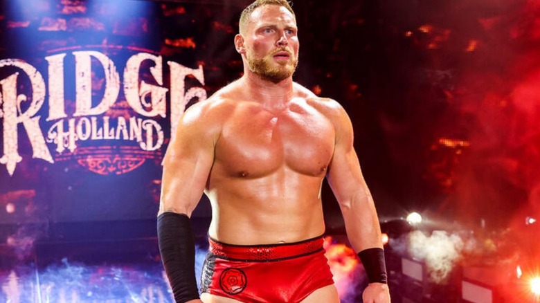 Ridge Hollands stands on the stage and looks to the ring before a match on 