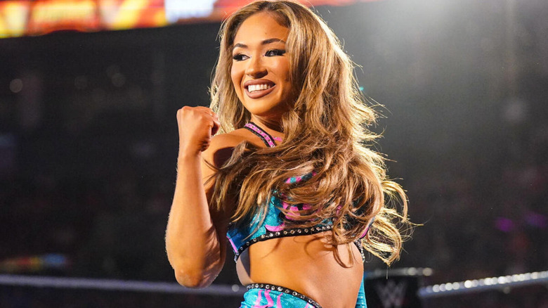 Lola Vice bears her fist as she flashes a wide smile.