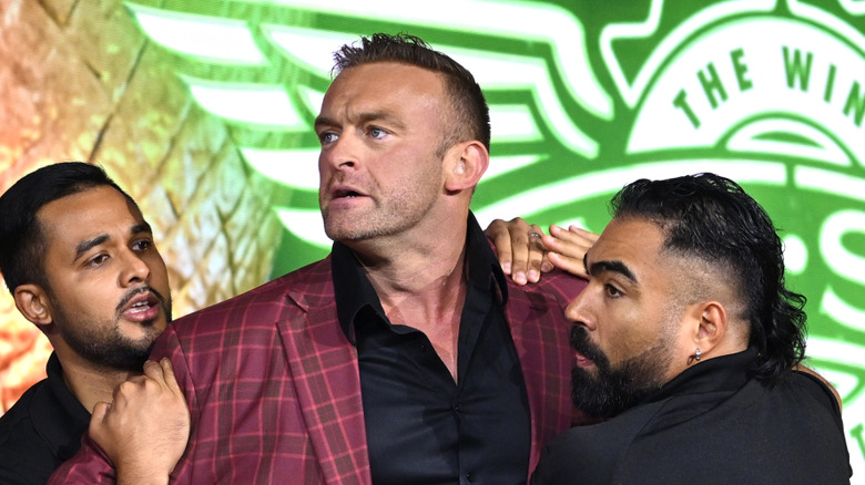 Nick Aldis standing in front of a Wingstop logo