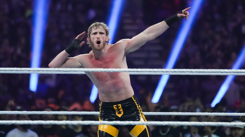 Logan Paul mocks the crowd by putting his hand up to his ear while pointing at the WrestleMania sign at Royal Rumble 2023