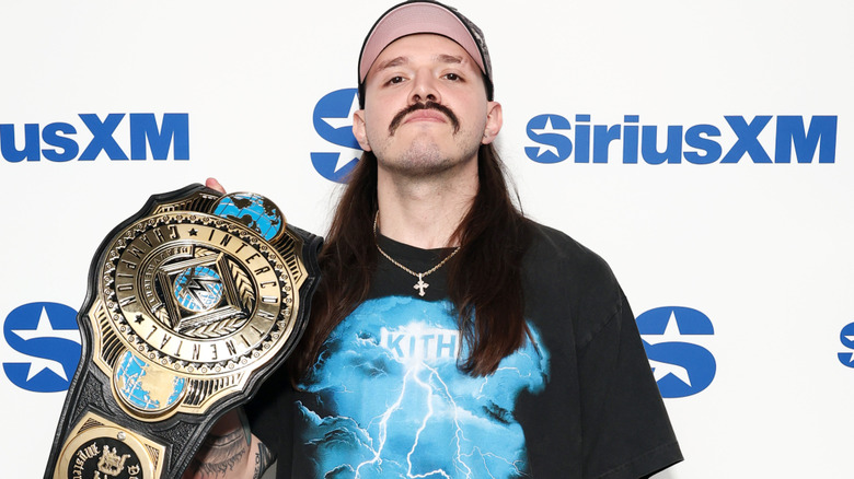 Dominik Mysterio holding the WWE Intercontinental championship