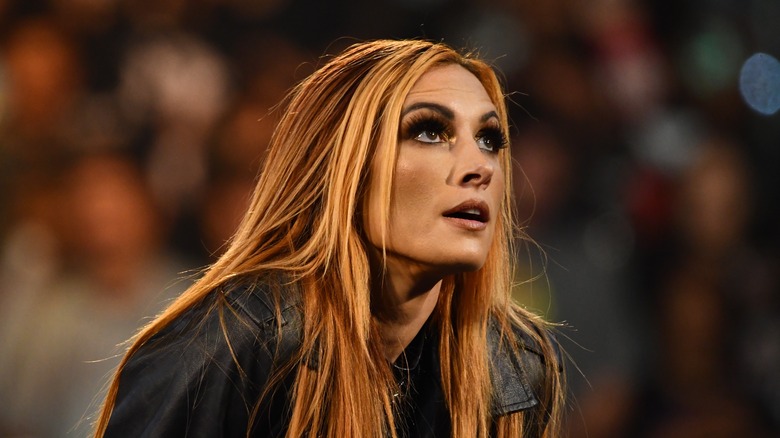 Becky Lynch looks up while wearing black leather jacket