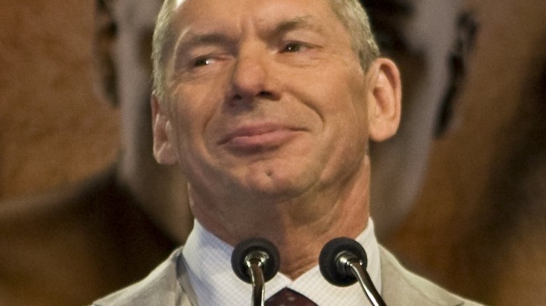 Vince McMahon smiling at a podium