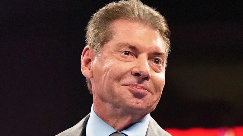 Vince McMahon smirks toward a WWE audience.