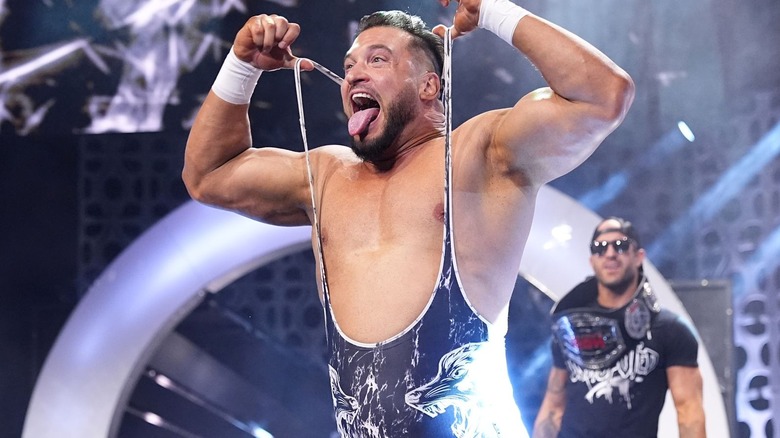 Wardlow sticks his tongue out and pulls at the sleeves of his singlet during his entrance.