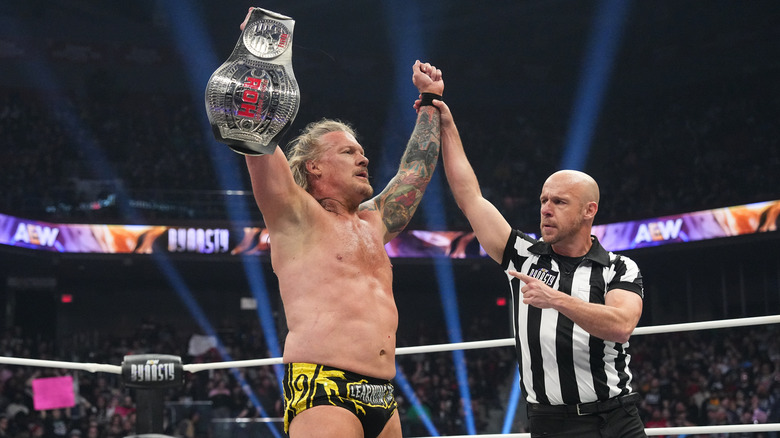Chris Jericho raises the ROH World Championship as a referee holds his hand in victory during the first finish of the match at AEW Dynasty 2025.