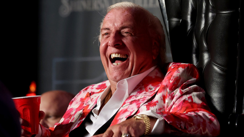 Ric Flair laughing with a drink in his hand