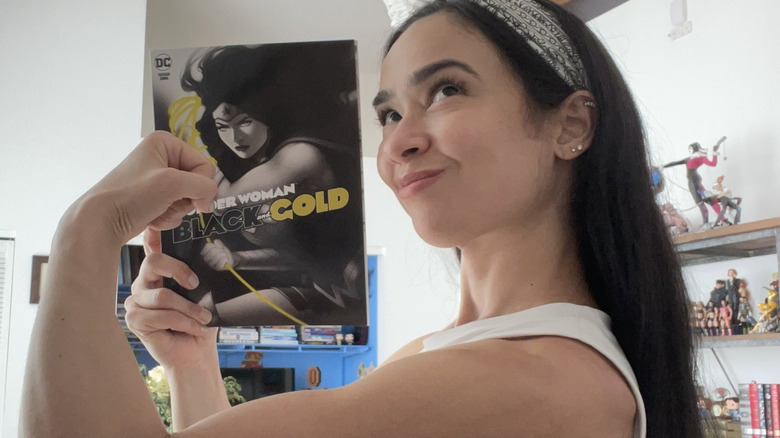 AJ Lee poses with "Women Woman Black and Gold," a comic that included one of her short stories, in a photo posted to her X account.