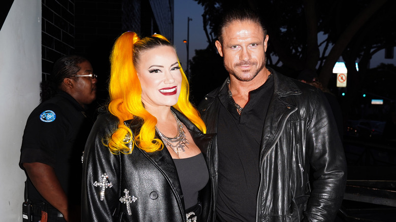 Taya Valkyrie and Johnny TV pose in front of what looks like a security guard