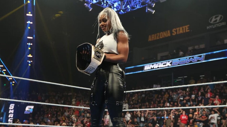 Jade Cargill holds the WWE Women's Championship, staring down at it in the middle of the ring, after turning heel on 