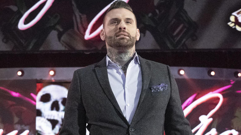 Corey Graves wearing a gray suit