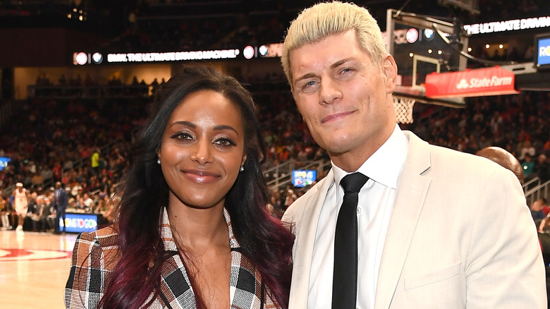 Cody Rhodes and Brandi Rhodes posing together at a basketball game