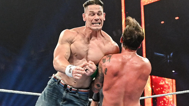 John Cena delivers a shoulder tackle to CM Punk.