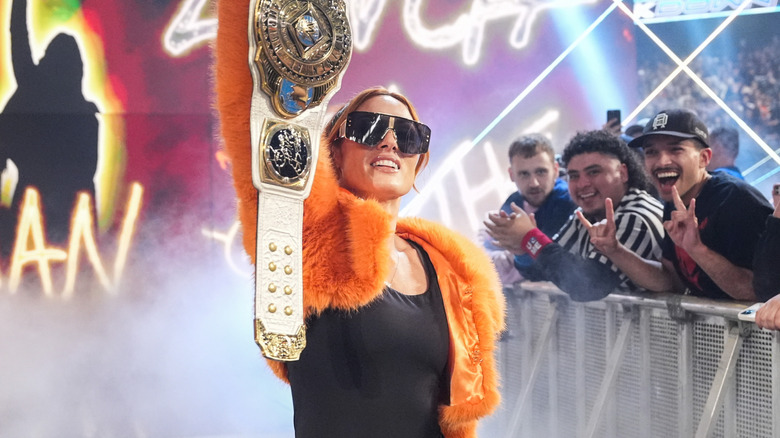 Becky Lynch holding WWE Women's Intercontinental Championship above her head during her entrance on 