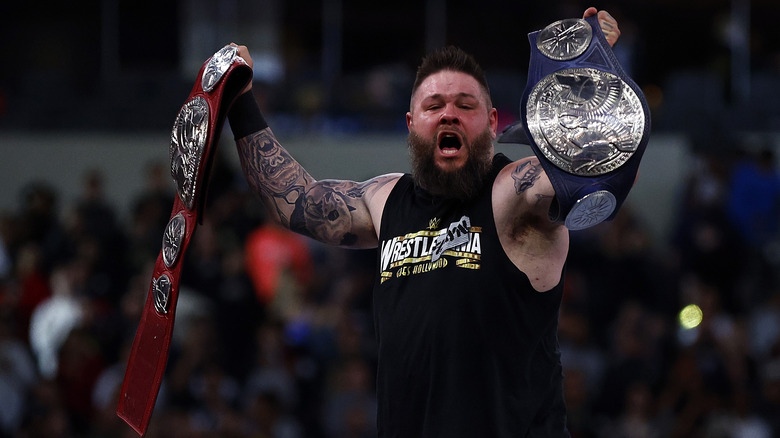 Kevin Owens celebrates with tag titles