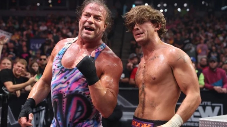 ECW Legend Rob Van Damm stands with AEW star HOOK outside the ring after a match.