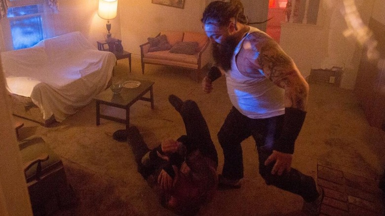 Bray Wyatt stands over Randy Orton in the floor of a living room during the House of Horrors match.