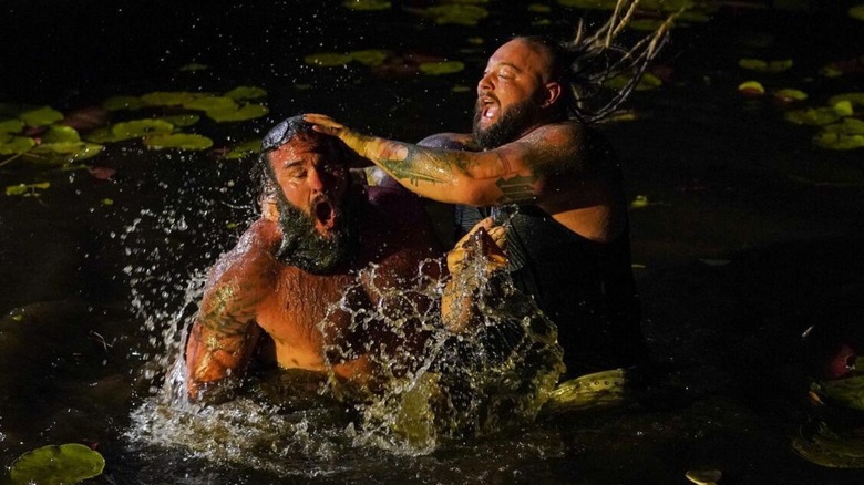 Bray Wyatt dunks Braun Strowman in the water of the swamp during their Wyatt Swamp Fight match.