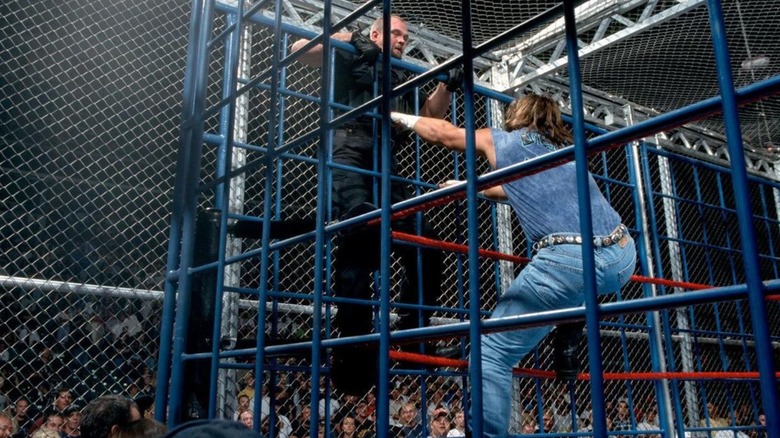 Big Boss Man and Al Snow climb the cage during their Kennel From Hell Match at Unforgiven 1999.