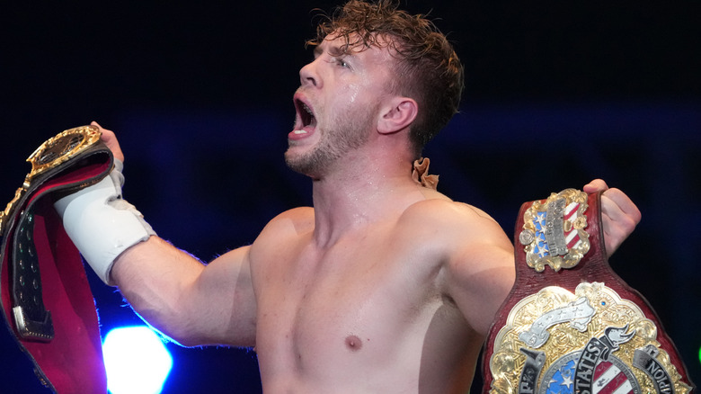 Will Ospreay holding title belts