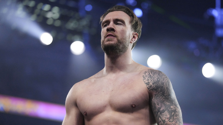 Will Ospreay stands in the ring and looks up the ramp toward Jon Moxley and the Death Riders following his return at AEW Revolution.