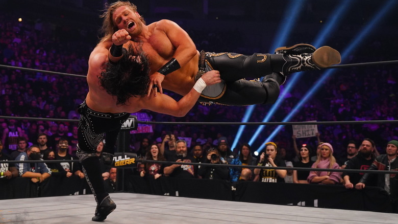 Hangman Adam Page hitting Kenny Omega with a lariat