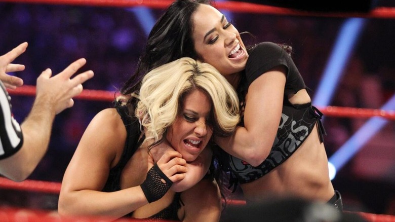 AJ Lee puts Kaitlyn in a headlock during a match for the WWE Divas Championship at Payback 2013.