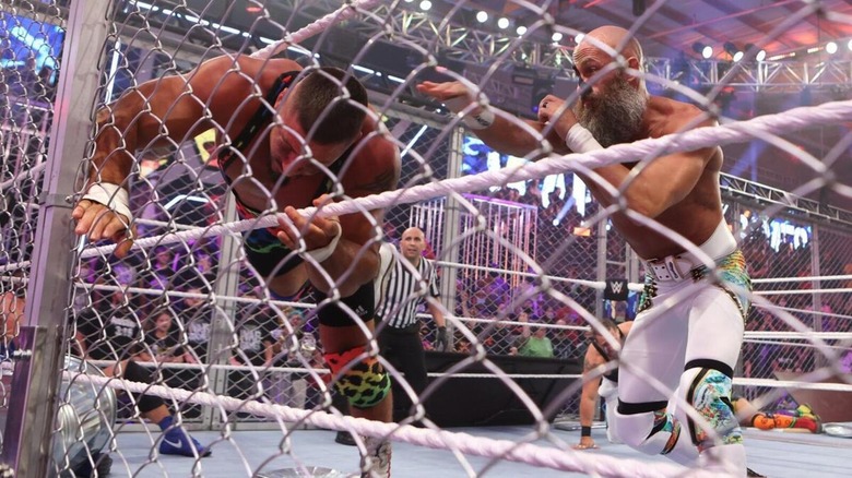 Tommaso Ciampa tosses Bron Breakker into the chainlink wall of a WarGames cage.