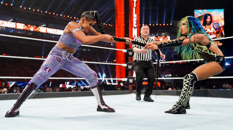 Sasha Banks looks frightened as she plays tug-of-war with Bianca Belair's braid at WrestleMania 37.