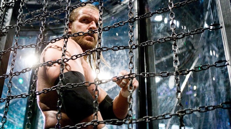 Triple H looks through the chains of the Elimination Chamber