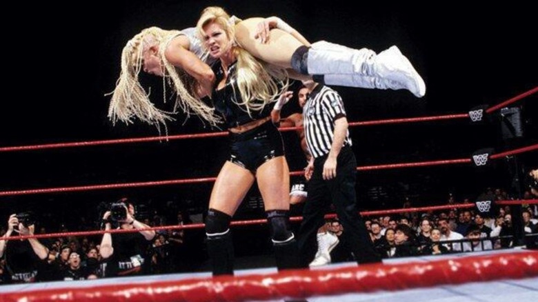 Sable gets Luna up on her shoulders during their mixed tag team match at WrestleMania 14.