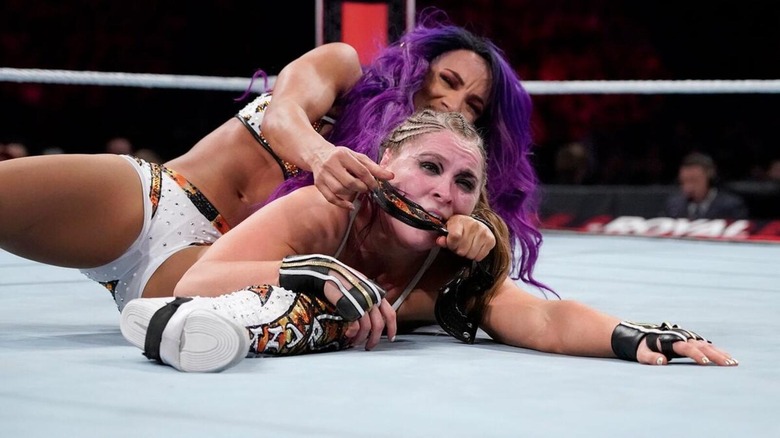 Sasha Banks uses a piece of her gear to lock in the Bank Statement on Ronda Rousey.