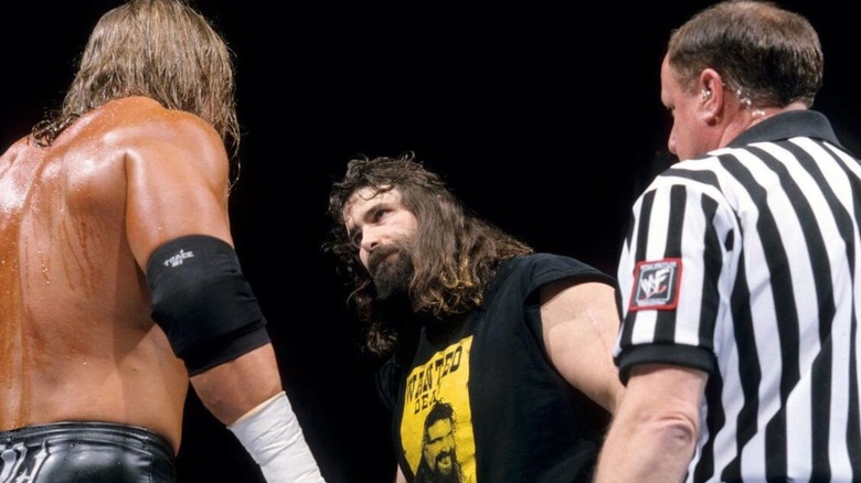 Cactus Jack stares down Triple H as a referee looks on ahead of their match at the 2000 Royal Rumble.