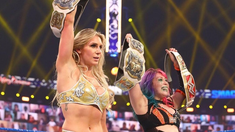 Charlotte Flair and Asuka pose with WWE Women's Tag Team Titles