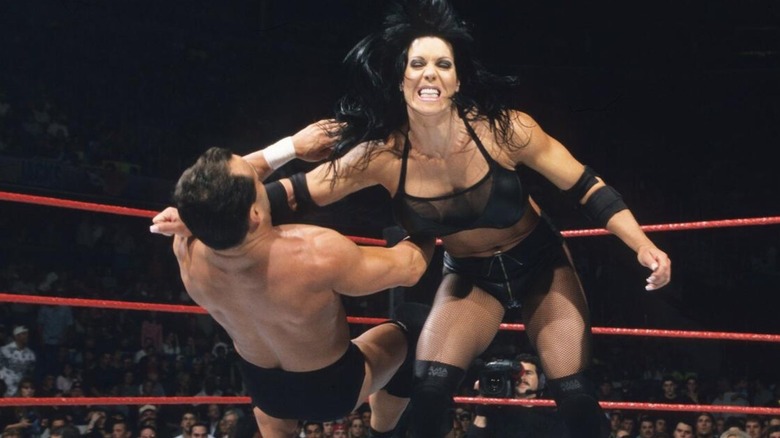 Chyna delivers a clothesline to Dean Malenko in the ring during a match at WrestleMania 2000.