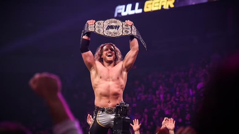 Hangman Adam Page holds up the AEW world title at Full Gear 2021