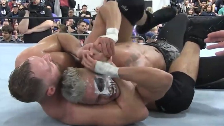 Jon Moxley attempts to get Darby Allin in a sleeper hold down on the mat during their 2019 match with Northeast Pro Wrestling.