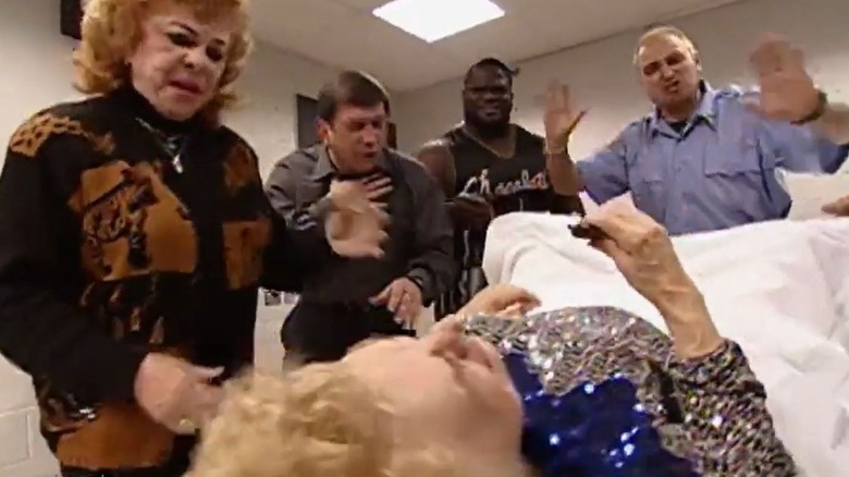 Mae Young goes into labor, Moolah, Mark Henry, and Gerald Briscoe around her, during the infamous segment where she births a hand on "WWE Raw."