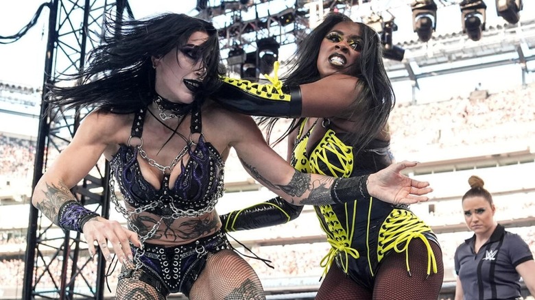 Naomi looks to throw Rhea Ripley into the ropes while in the ring during their triple threat match involving IYO SKY at WrestleMania 41.