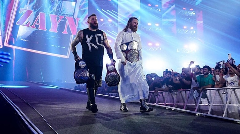 Kevin Owens and Sami Zayn walk down the ramp wearing tag team gold at WWE Night of Champions 2023