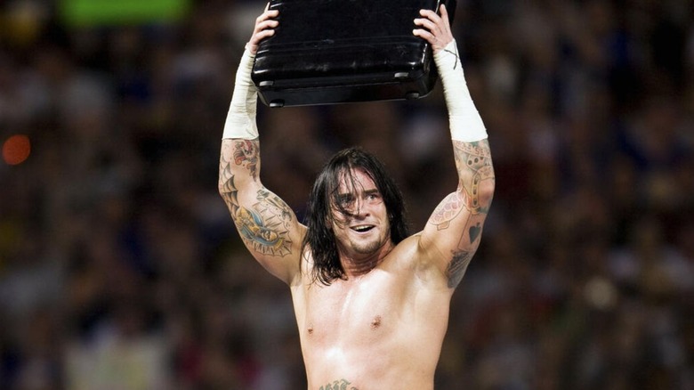 CM Punk holds up the Money in the Bank briefcase after winning it for the first time at WrestleMania 24 in 2008.