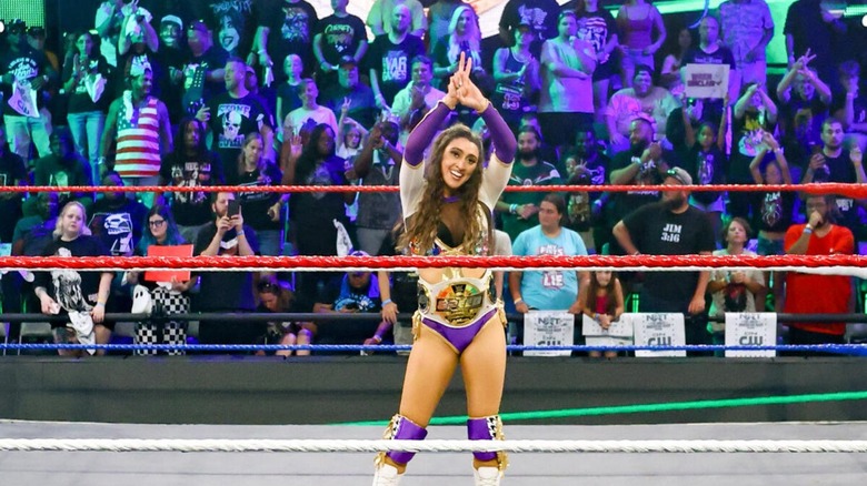 WWE Women's Speed Champion Wren Sinclair poses in the ring, the title round her waist, ahead of her match against Arianna Grace at 