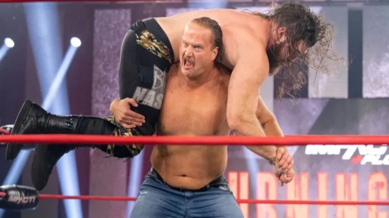 Joe Doering puts an opponent over his shoulders to set up a move during a match in Impact Wrestling.